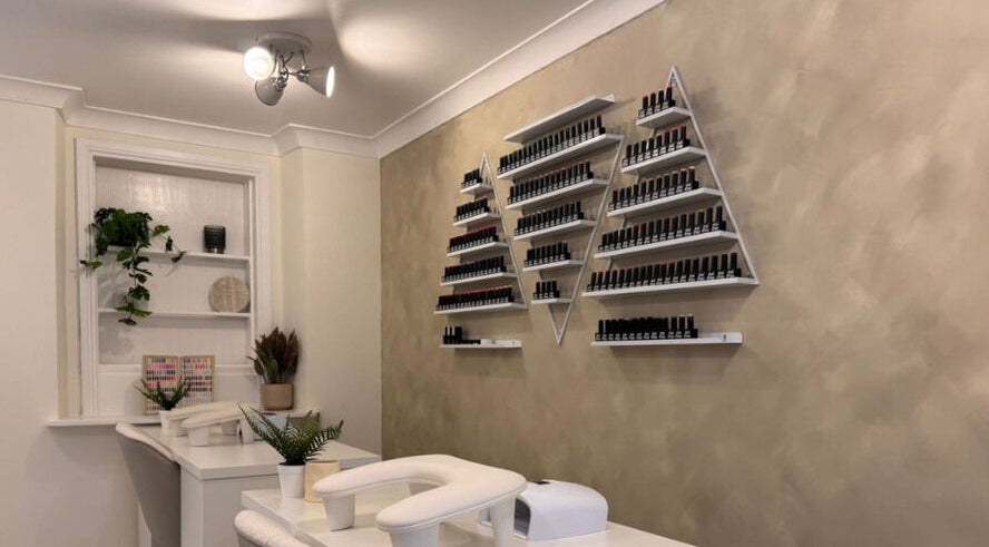 Simply Beauty nail polish display setup in Ramsey, Ramsey, IM, featuring sleek wall-mounted shelves.