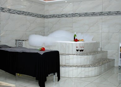 Luxurious spa room at Semeni Asante Spa in Johannesburg, Gauteng, ZA with a bubbling bath and elegant decor.