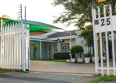 Entrance of Semeni Asante Spa, Johannesburg, Gauteng, ZA, showcasing white gates and green awning.