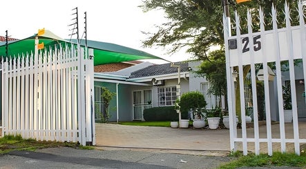 Entrance of Semeni Asante Spa, Johannesburg, Gauteng, ZA, showcasing white gates and green awning.