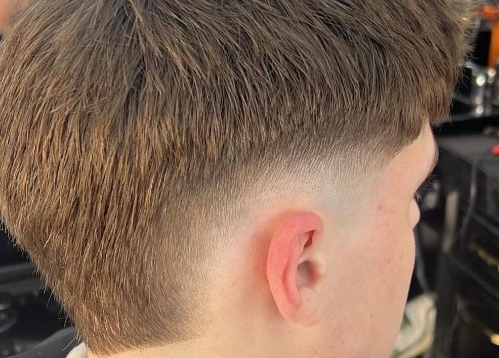Close-up of a fresh fade haircut at Eden Barbers, Potters Bar, England, GB. Modern hairstyle shown at the ear level.