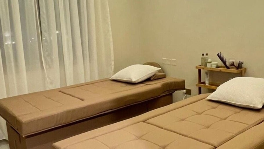 Relaxing massage room at The Glossary, Hawally, Hawalli Governorate, KW, featuring two elegant treatment beds.
