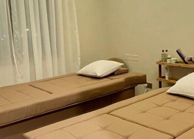Relaxing massage room at The Glossary, Hawally, Hawalli Governorate, KW, featuring two elegant treatment beds.