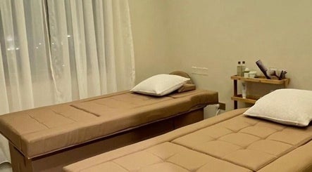 Relaxing massage room at The Glossary, Hawally, Hawalli Governorate, KW, featuring two elegant treatment beds.