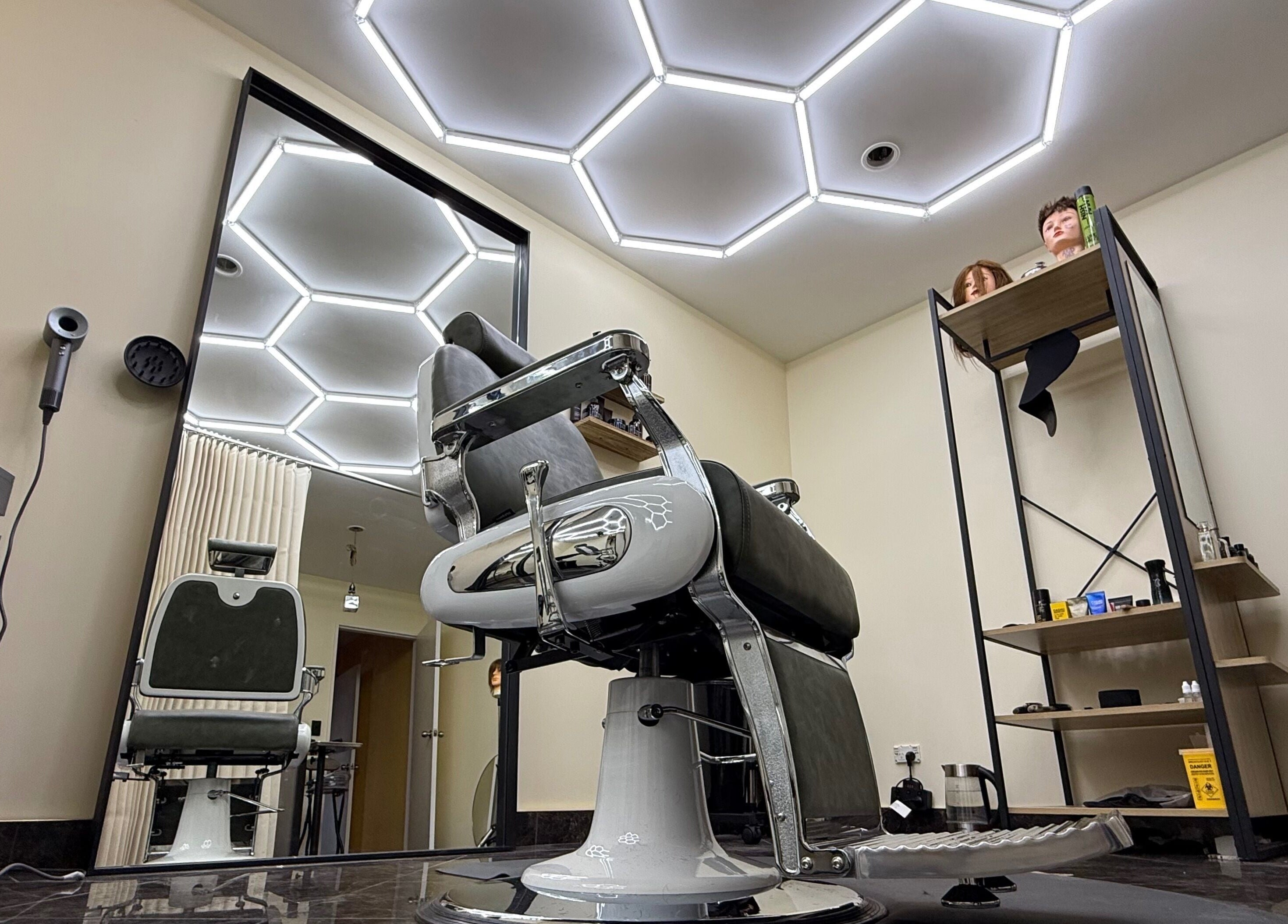 Modern barber chair and ceiling lights at Park And Cut, Auckland, NZ. Sleek design in a stylish salon setting.