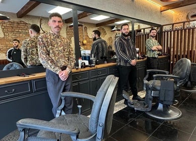 Stylish interior of EAST FINCHLEY BARBERS, London, England, GB with barbers awaiting clients.
