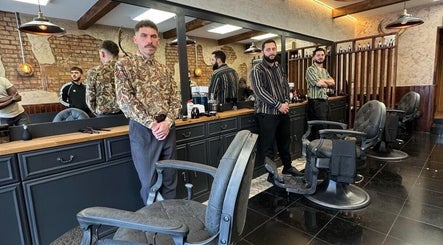 Stylish interior of EAST FINCHLEY BARBERS, London, England, GB with barbers awaiting clients.