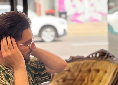 Client seated comfortably at EAST FINCHLEY BARBERS in London, England, GB, enjoying a moment of relaxation.