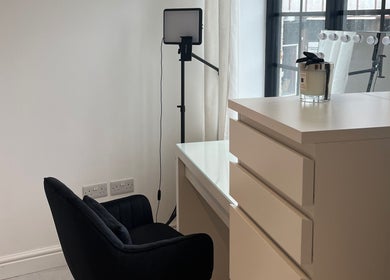 Emma Dave MUA's elegant vanity setup with black chair, soft lighting in Bridgend, Wales, GB.