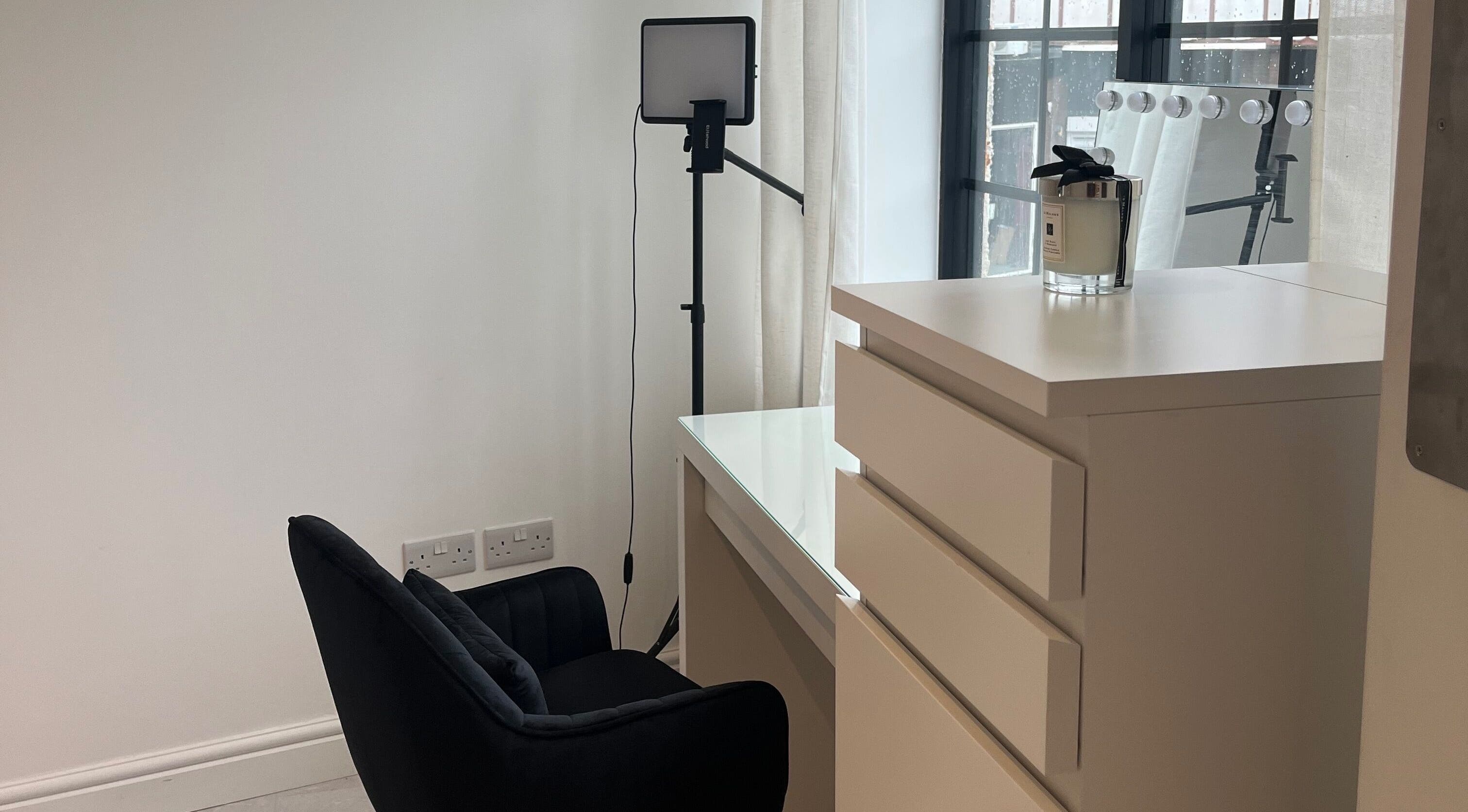 Emma Dave MUA's elegant vanity setup with black chair, soft lighting in Bridgend, Wales, GB.
