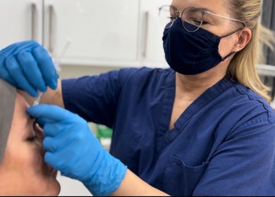 Clinician at Dalya Cosmo clinic in London, England, GB, administering a cosmetic treatment with precision.