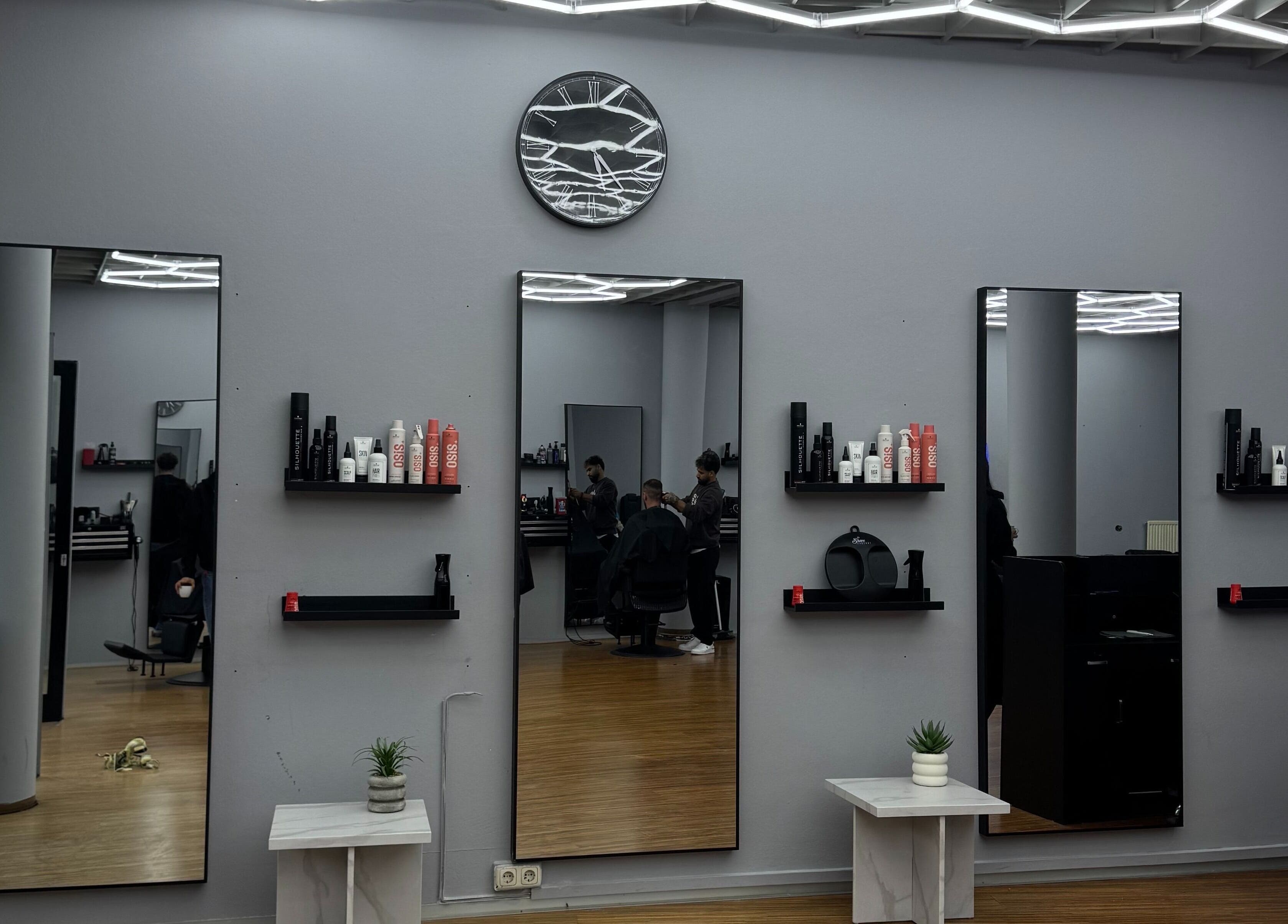 Innenansicht von Fade and Flair, Graz, Steiermark, AT, mit Spiegeln und Pflegeprodukten.