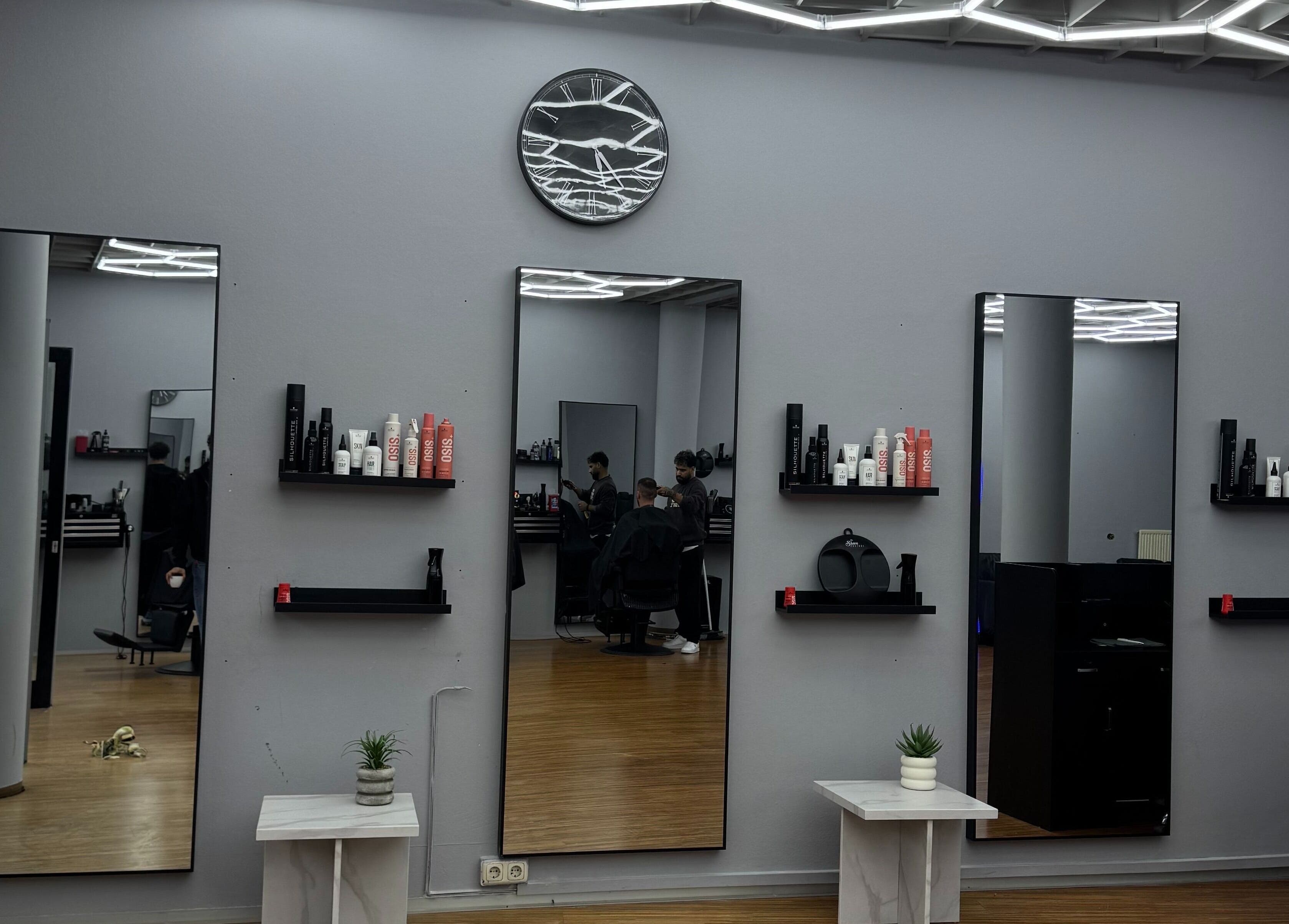 Moderner Salon bei Fade and Flair in Graz, Steiermark, AT mit stilvoller Spiegelwand und Pflegeprodukten.