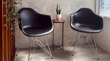 Modern black chairs in the waiting area of Fab Curls, Bayamón, Bayamón, PR, offering a welcoming ambience.