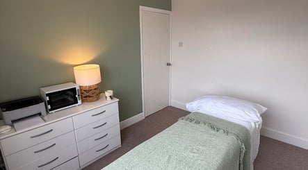 Tranquil therapy room at Jessica's at Chichester, featuring soft lighting and cozy bedding, Chichester, England, GB.