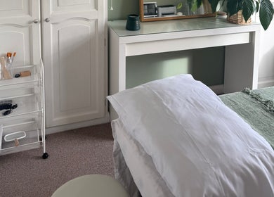 Tranquil treatment room at Jessica's at Chichester, Chichester, England, GB, with bed and green decor.