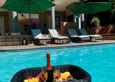 Relaxing poolside at SoulSpring Sports & Wellness Spa, Pretoria, Gauteng, ZA with champagne and sun loungers.