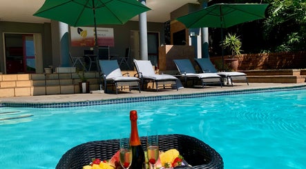 Relaxing poolside at SoulSpring Sports & Wellness Spa, Pretoria, Gauteng, ZA with champagne and sun loungers.