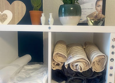 Cozy shelves with towels and decor at Replay Massage in Cardiff, Wales, GB, offering a serene atmosphere.