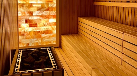 Warm wooden sauna at Naturelife Spa Marina Abu Dhabi, Abu Dhabi, AE, featuring glowing salt wall.