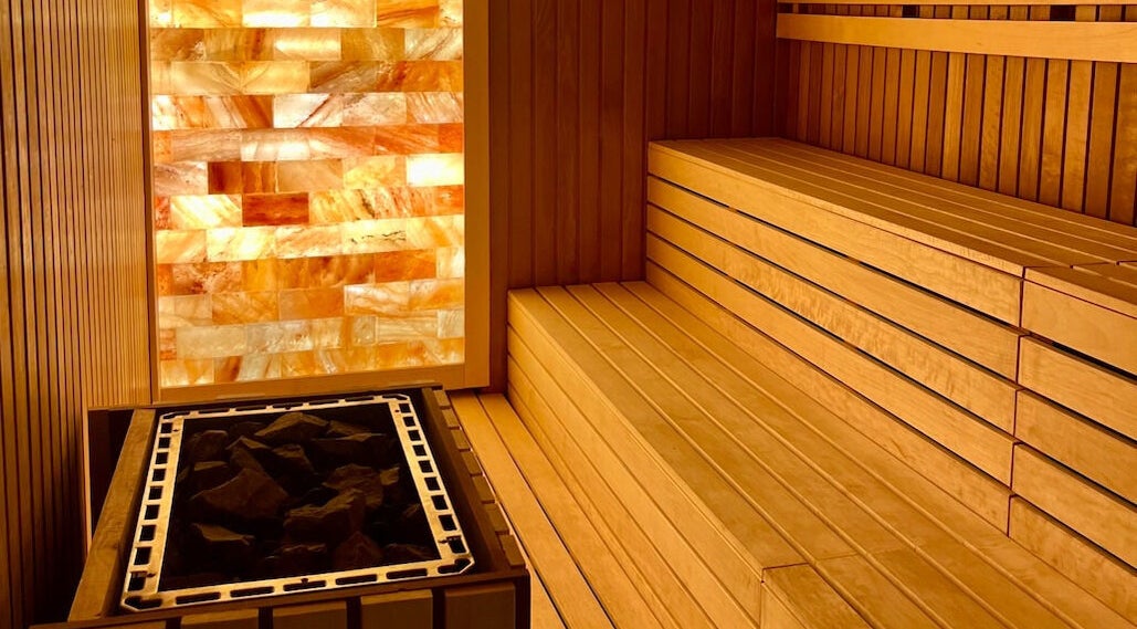 Warm wooden sauna at Naturelife Spa Marina Abu Dhabi, Abu Dhabi, AE, featuring glowing salt wall.