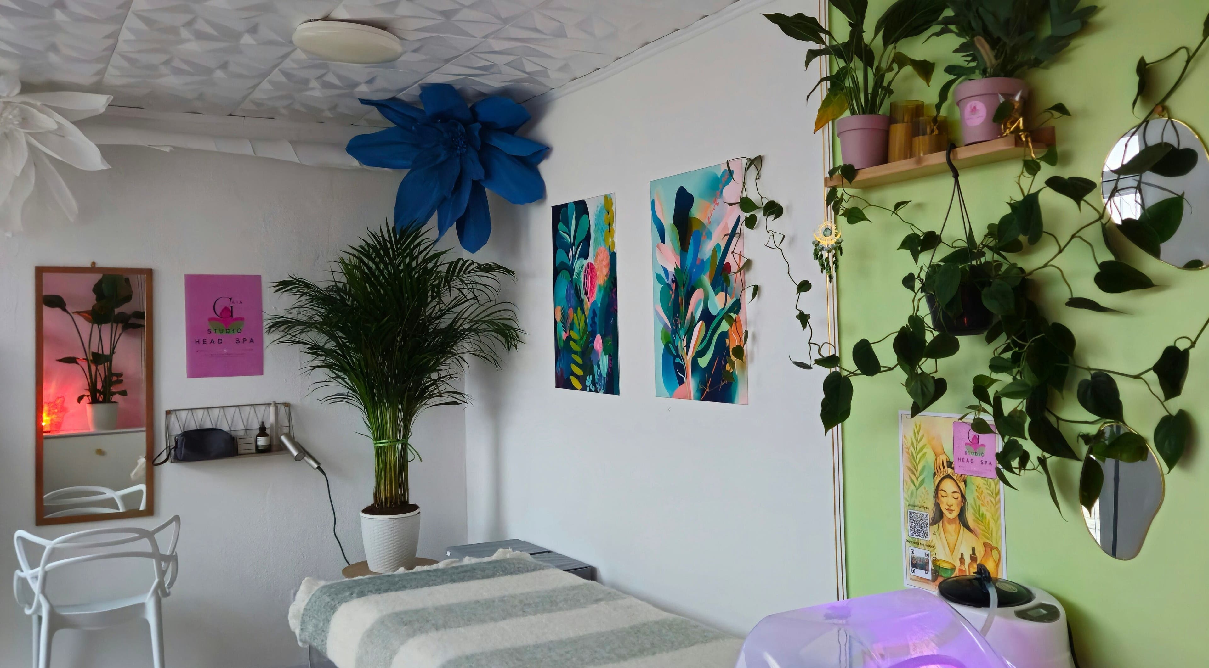 Przytulne wnętrze GAIA Studio Head Spa w Puławy, Województwo Lubelskie, PL z roślinnością i sztuką na ścianach.