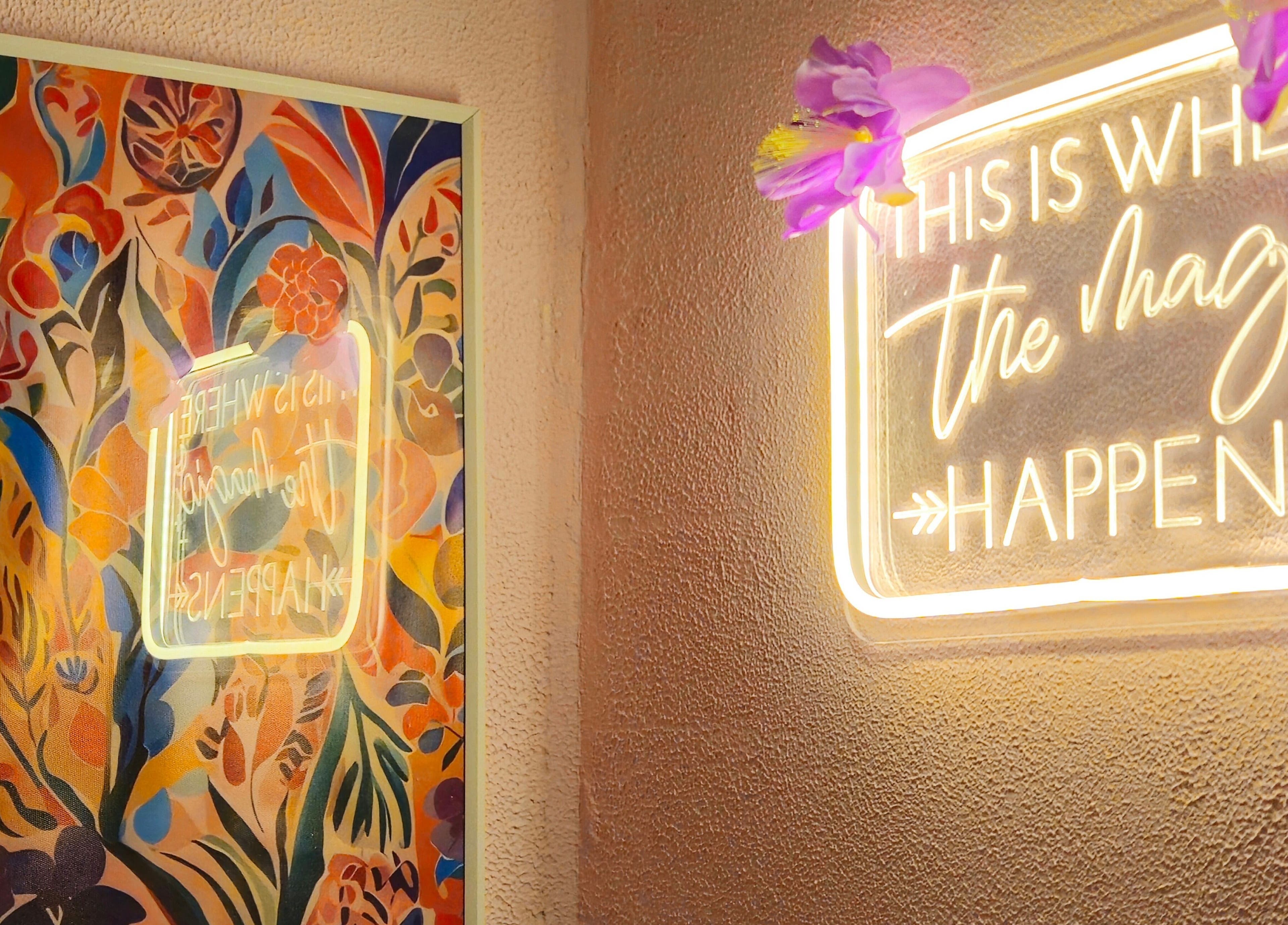 Kolorowy mural i neon z napisem 'This is where the magic happens' w GAIA Studio Head Spa, Puławy, PL.