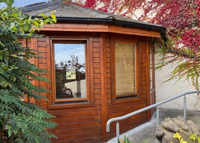 Entrance to Listening Fields Holistic Massage, Dublin City Centre, showcasing a serene wooden exterior with vibrant ivy.