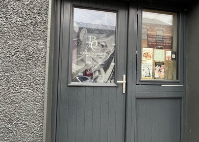 Front entrance of The Beauty Collective in Cork, County Cork, IE, showcasing stylish design and promotional posters.