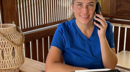 Medewerker bij El Fuego Pedicure en Manicure, Willemstad, CW, aan telefoon in houten spa-omgeving.