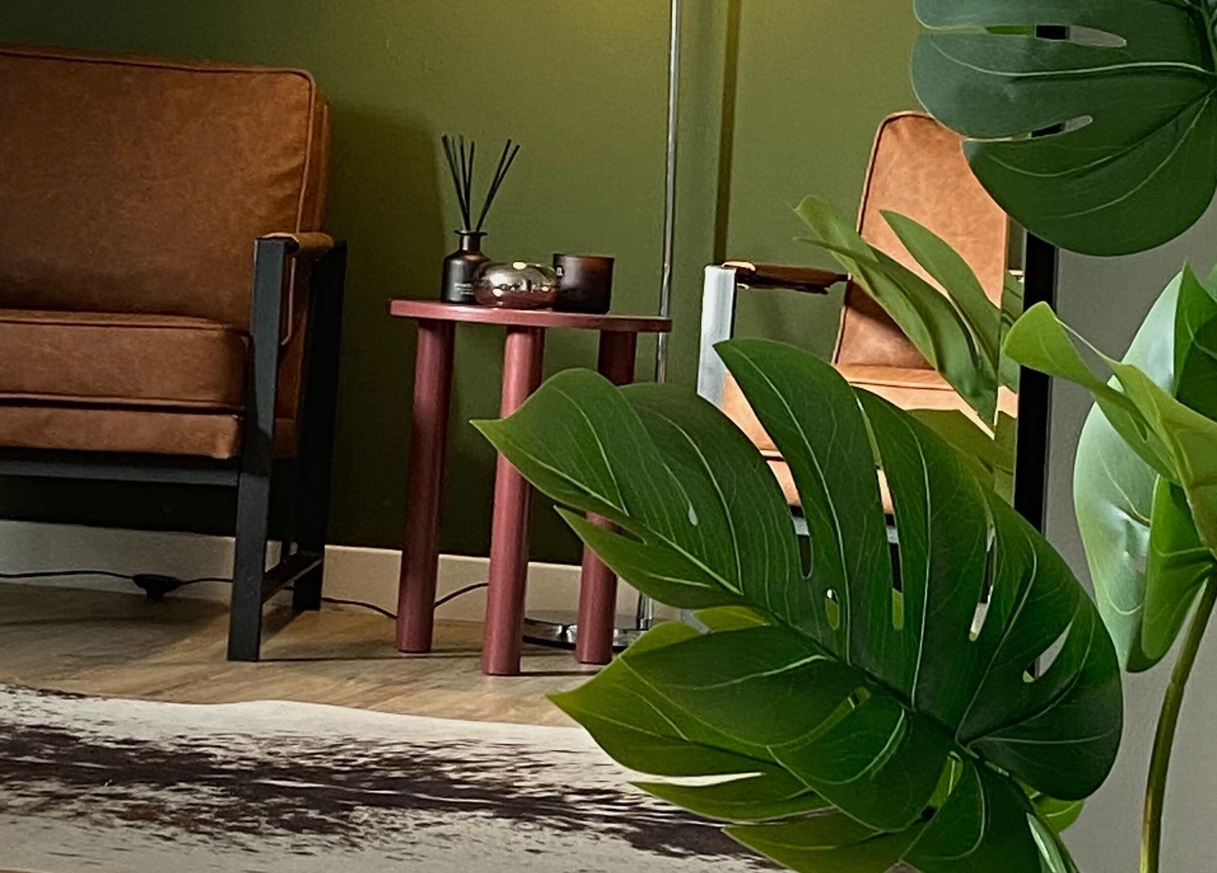 Stylish seating area at June Studios, Edinburgh, Scotland, GB featuring leather chairs and lush plants.