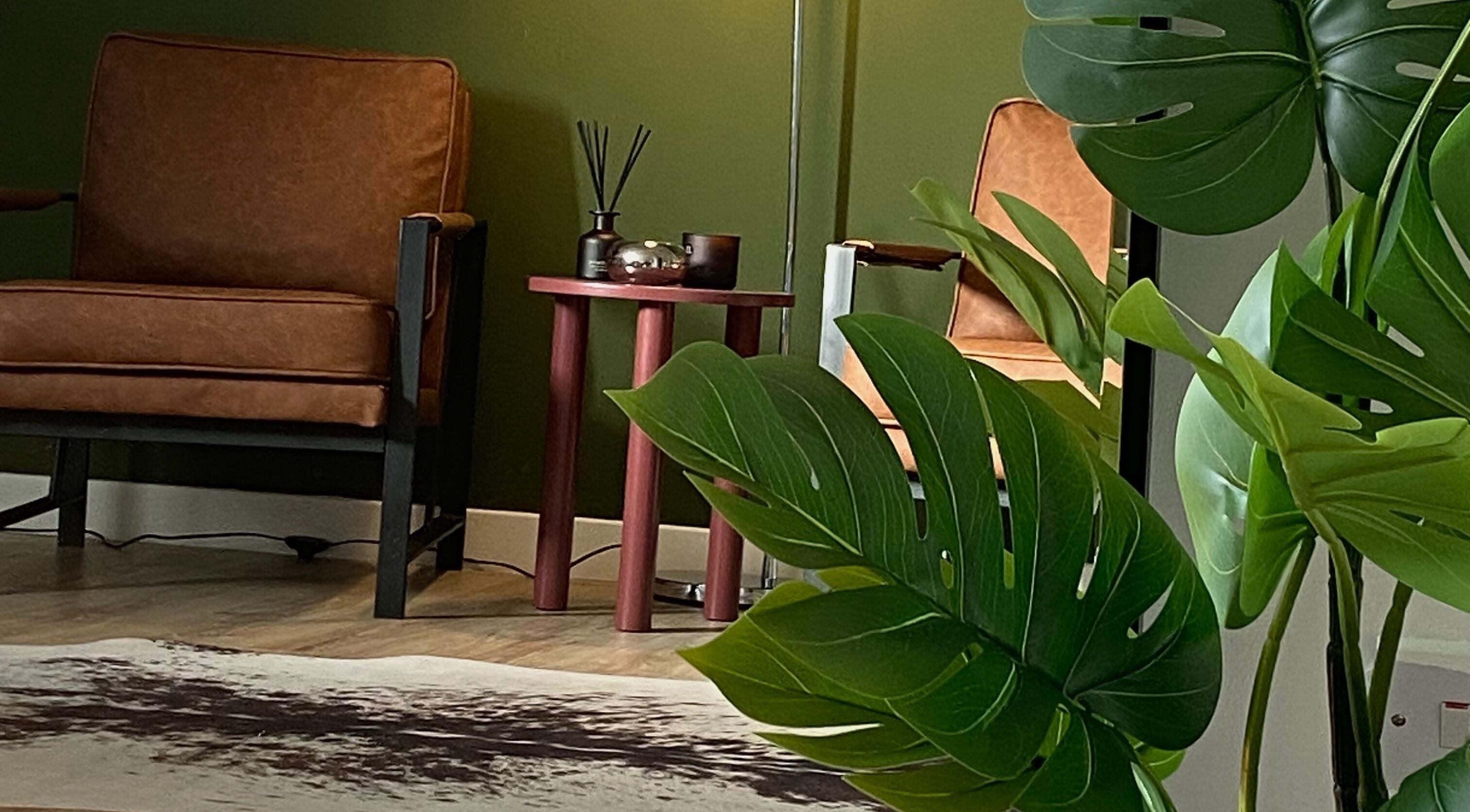 Stylish seating area at June Studios, Edinburgh, Scotland, GB featuring leather chairs and lush plants.