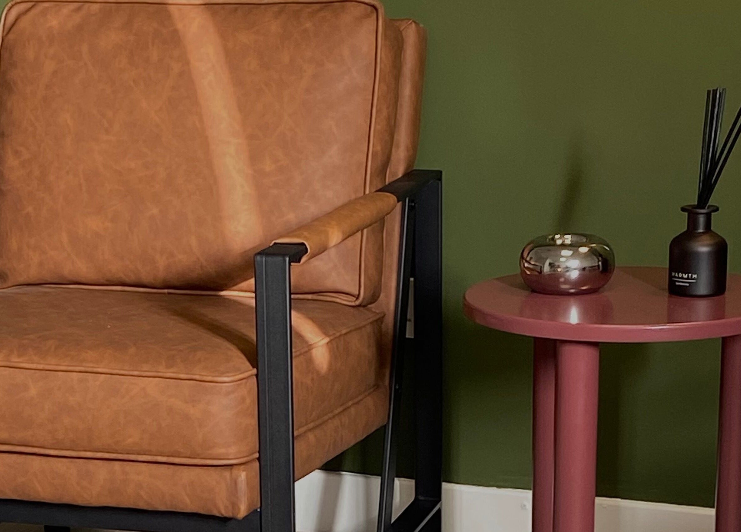Elegant brown chair and sleek side table in June Studios, Edinburgh, Scotland, GB offer a cozy retreat.