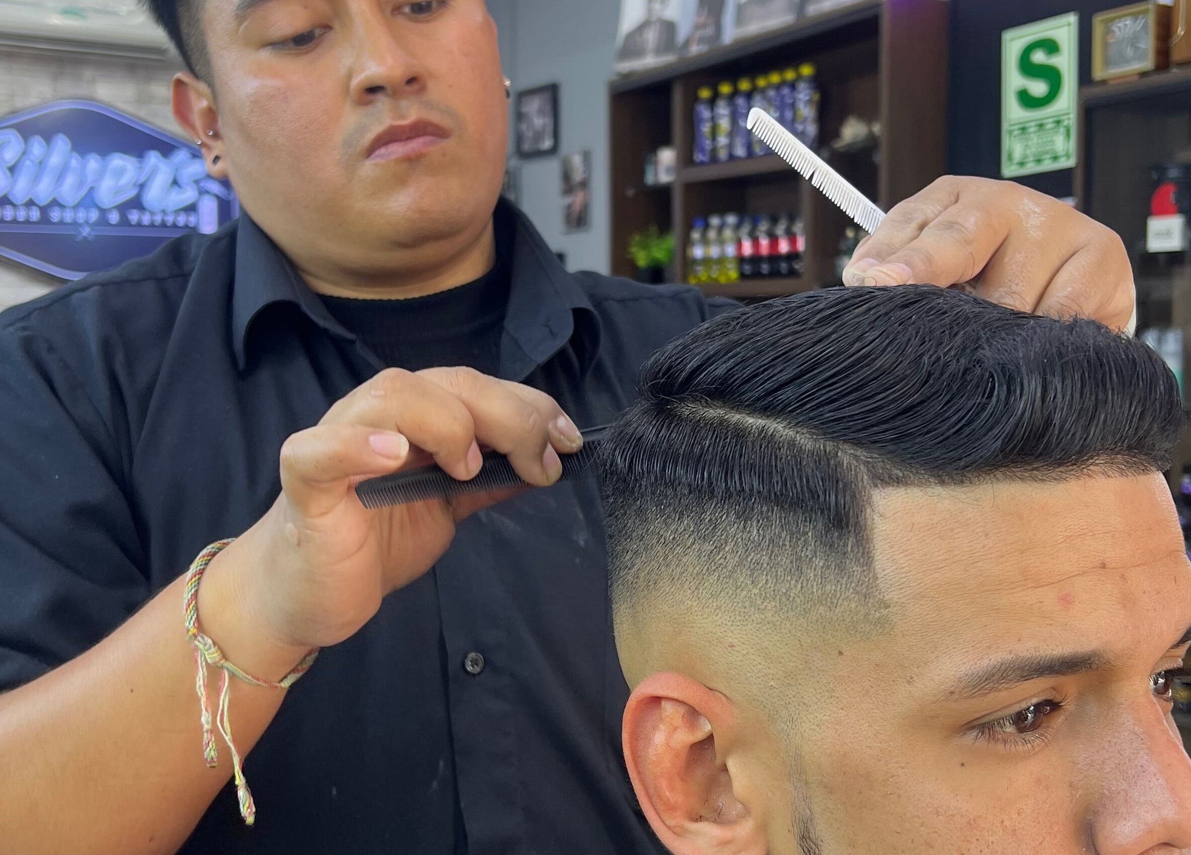 Estilista de ALESSANDRO CUT’S, Lima, Provincia De Lima, PE, peinando a un cliente con técnica precisa.