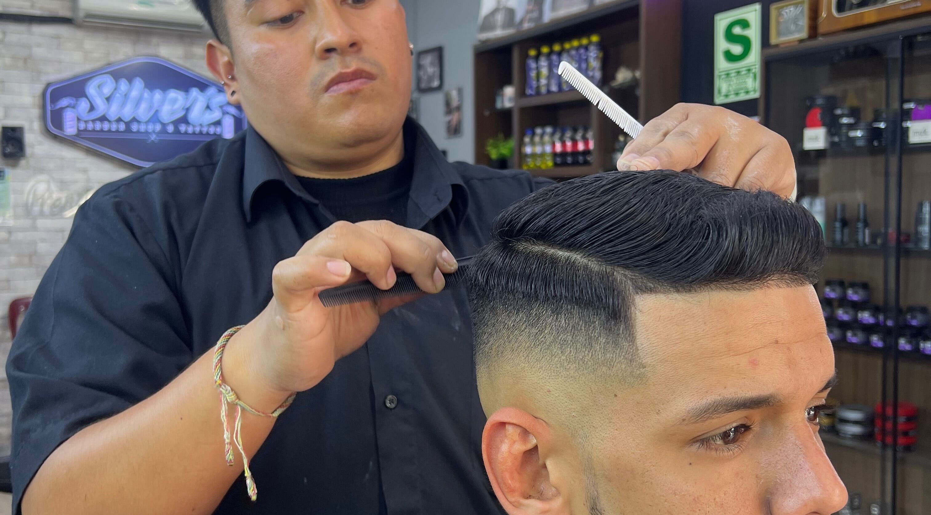 Estilista de ALESSANDRO CUT’S, Lima, Provincia De Lima, PE, peinando a un cliente con técnica precisa.