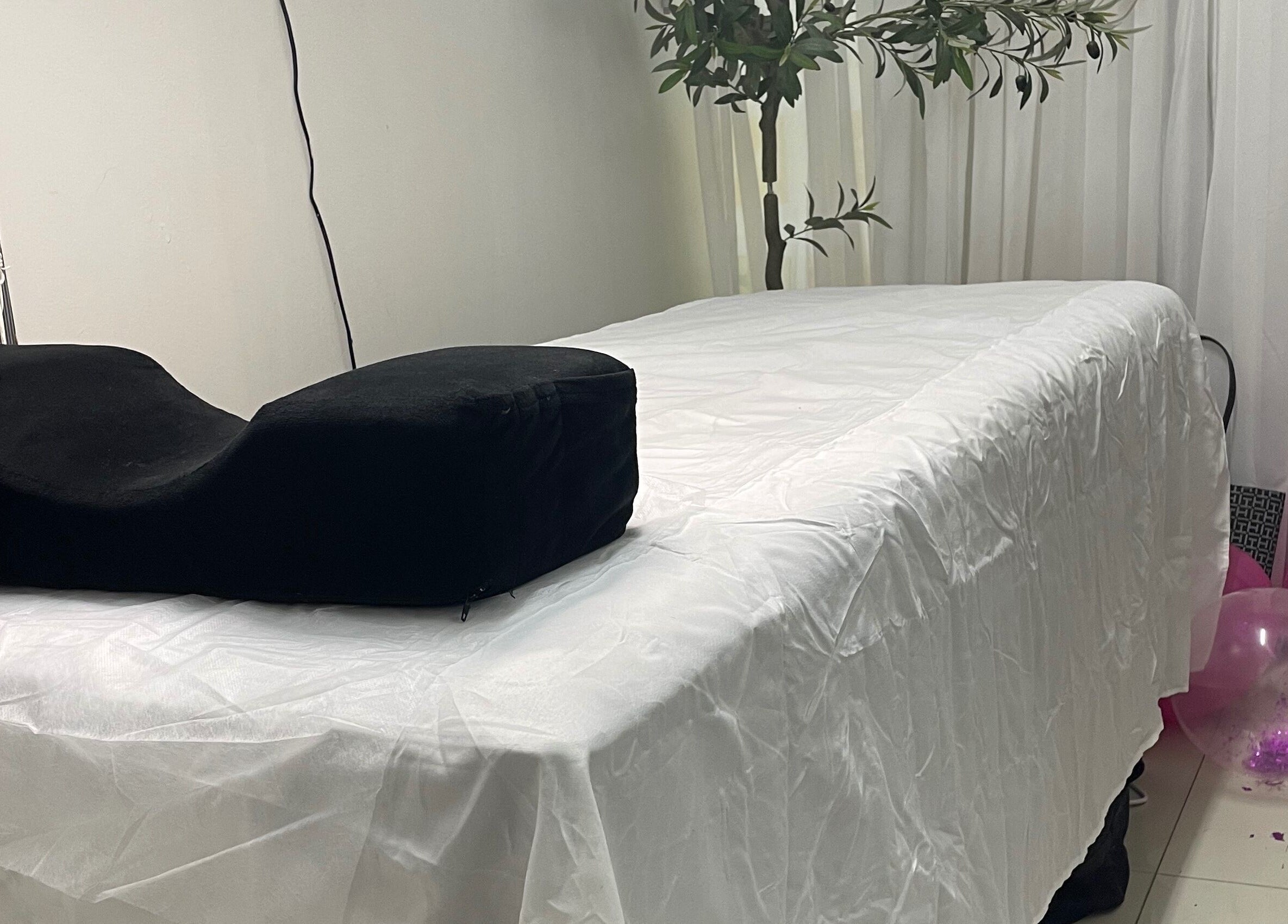 Massage bed at Donna Marie Skin Pharm, Old Harbour, St. Catherine Parish, JM surrounded by plants and decor.