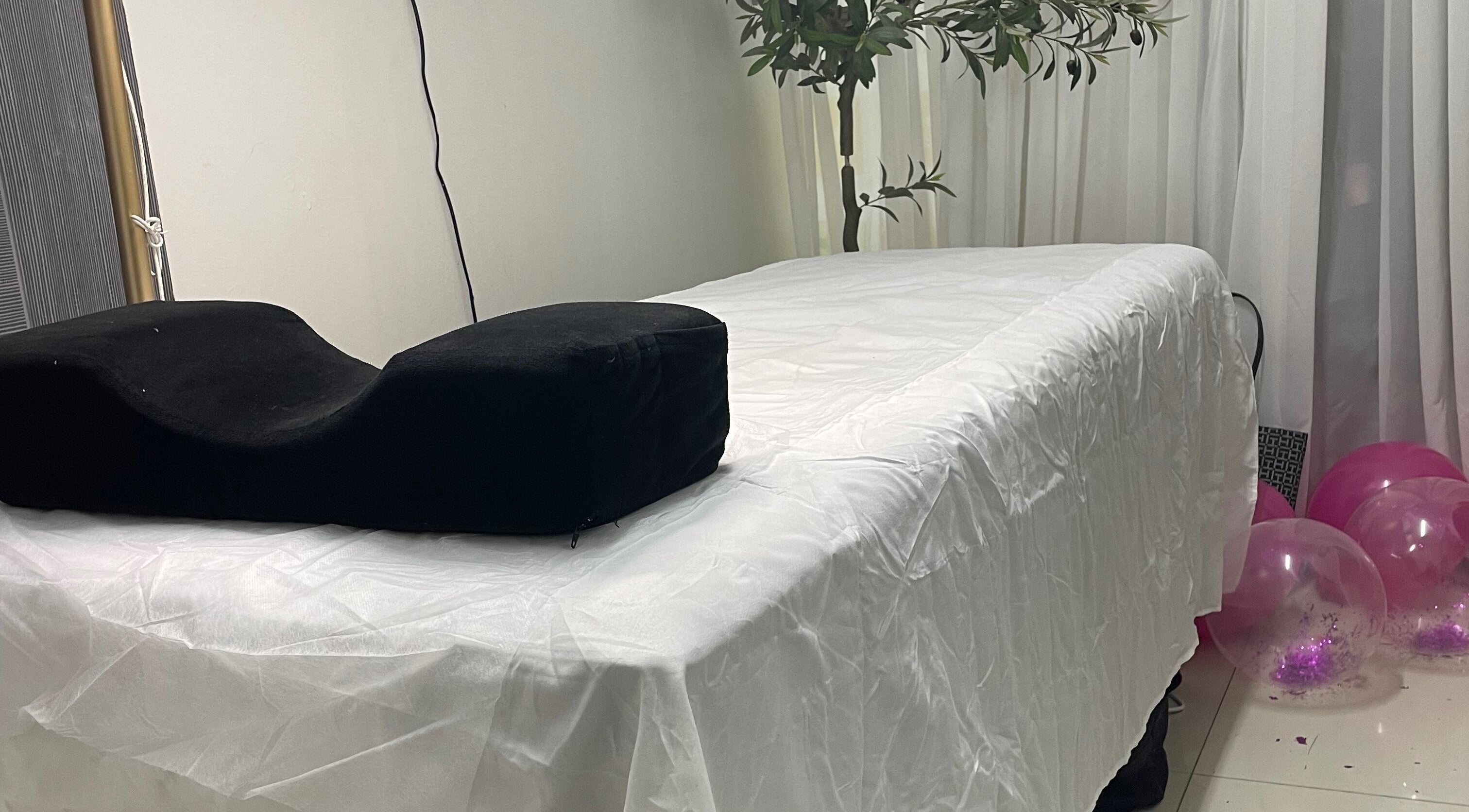 Massage bed at Donna Marie Skin Pharm, Old Harbour, St. Catherine Parish, JM surrounded by plants and decor.