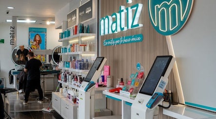 Interior del salón Matiz Milagro en La Serena, Coquimbo, CL, mostrando productos de belleza en estantes.
