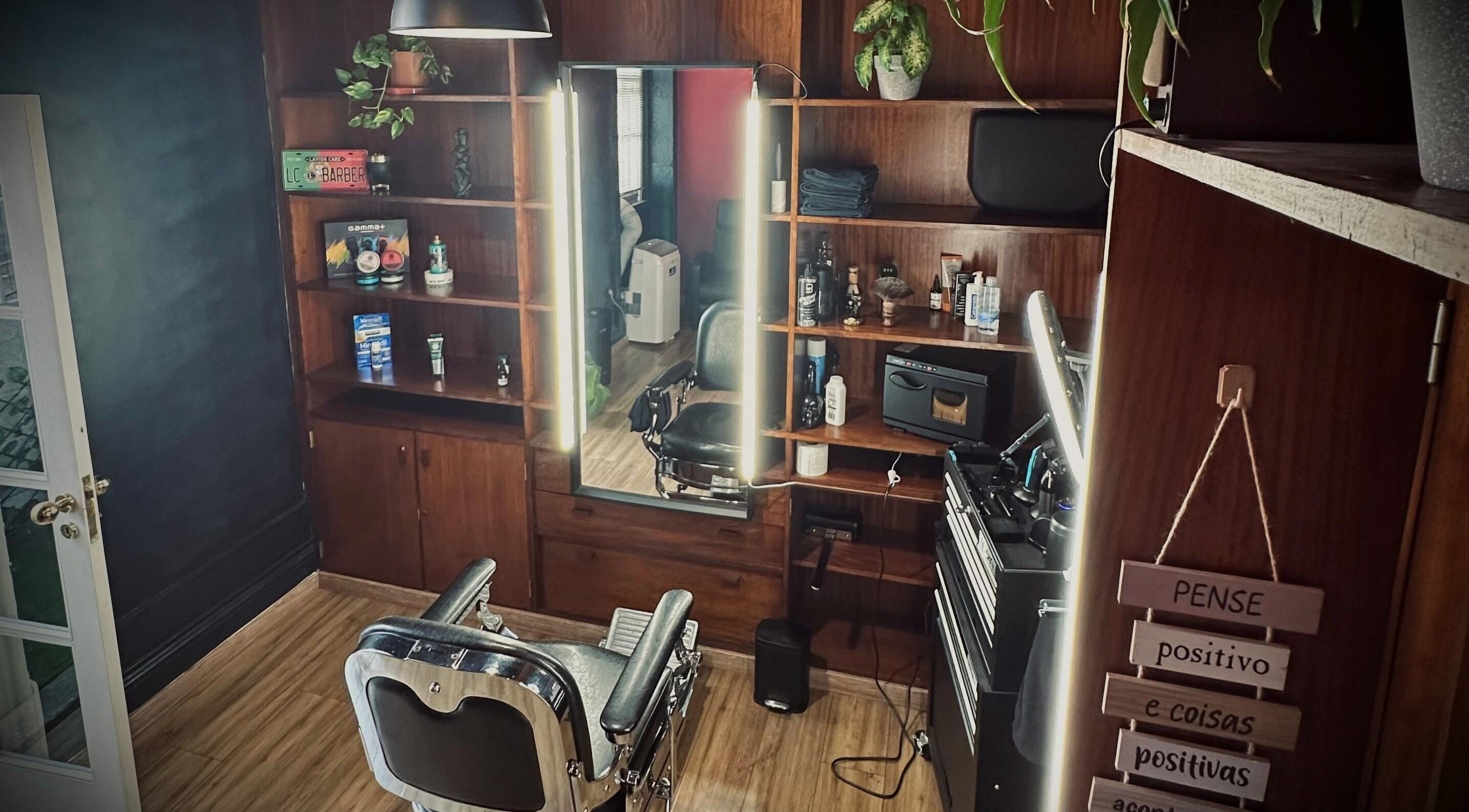 Interior de ProsBarberStudio en Porto, Porto, PT, mostrando un sillón de barbero clásico y estantes de madera.