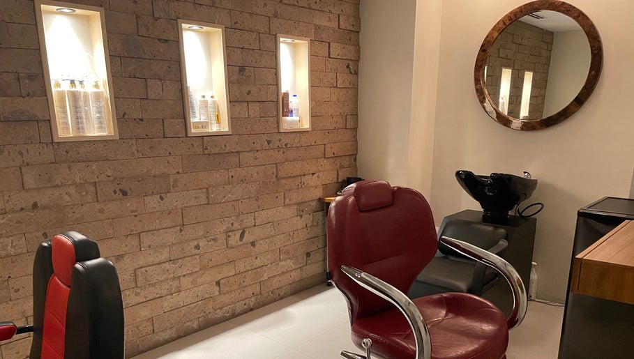 Interior elegante de N&H Vital Hair en Chihuahua, Chihuahua, MX con sillas de salón y productos iluminados.