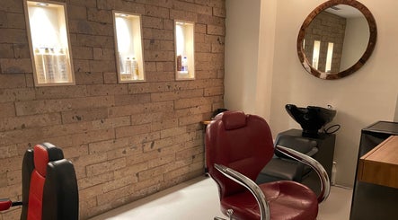 Interior elegante de N&H Vital Hair en Chihuahua, Chihuahua, MX con sillas de salón y productos iluminados.