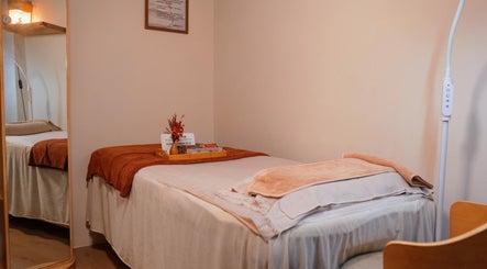 Relaxing treatment room at Caballe.M Organic Skin Spa - Toa Payoh, Singapore, SG, featuring cozy bed and warm decor.