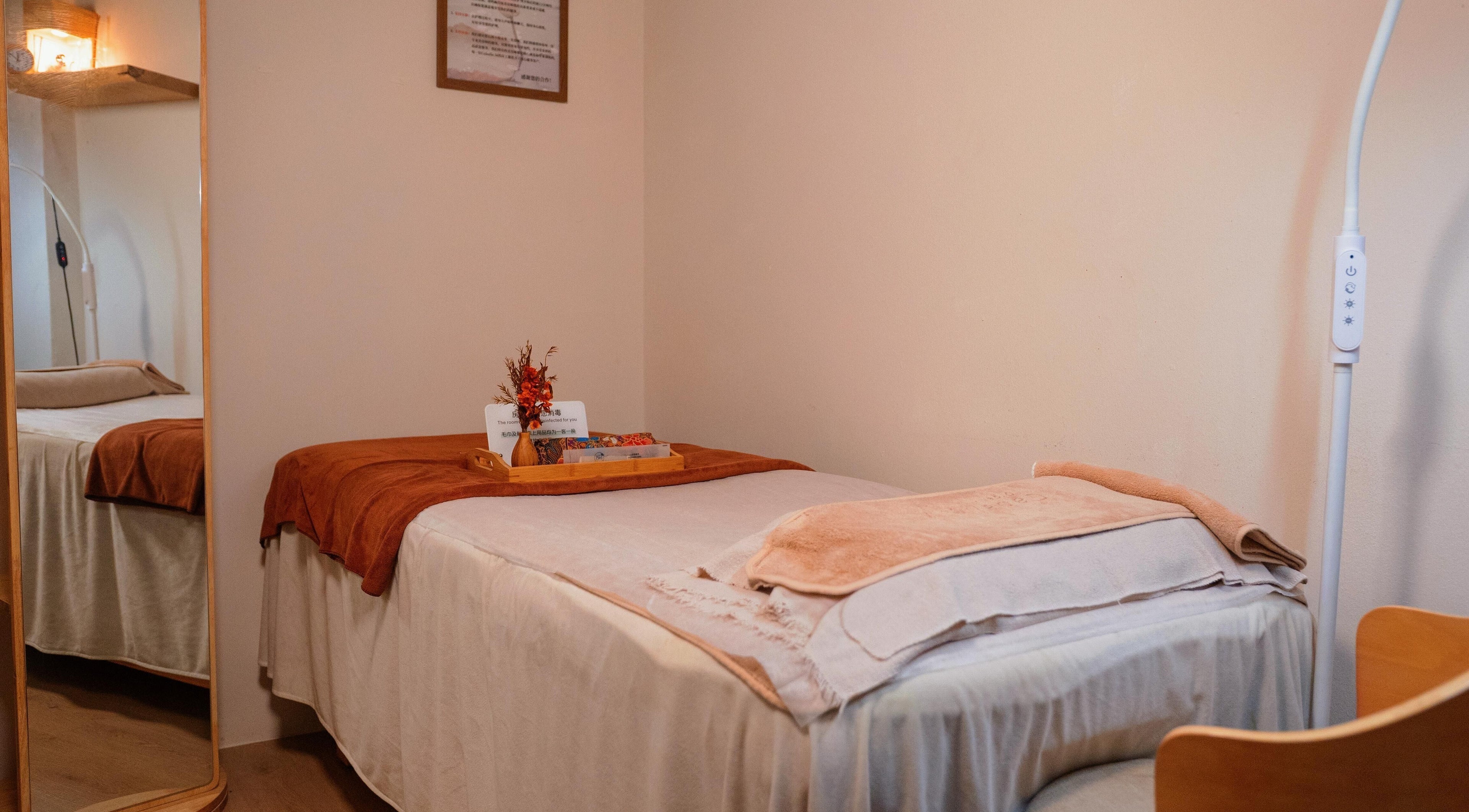 Relaxing treatment room at Caballe.M Organic Skin Spa - Toa Payoh, Singapore, SG, featuring cozy bed and warm decor.