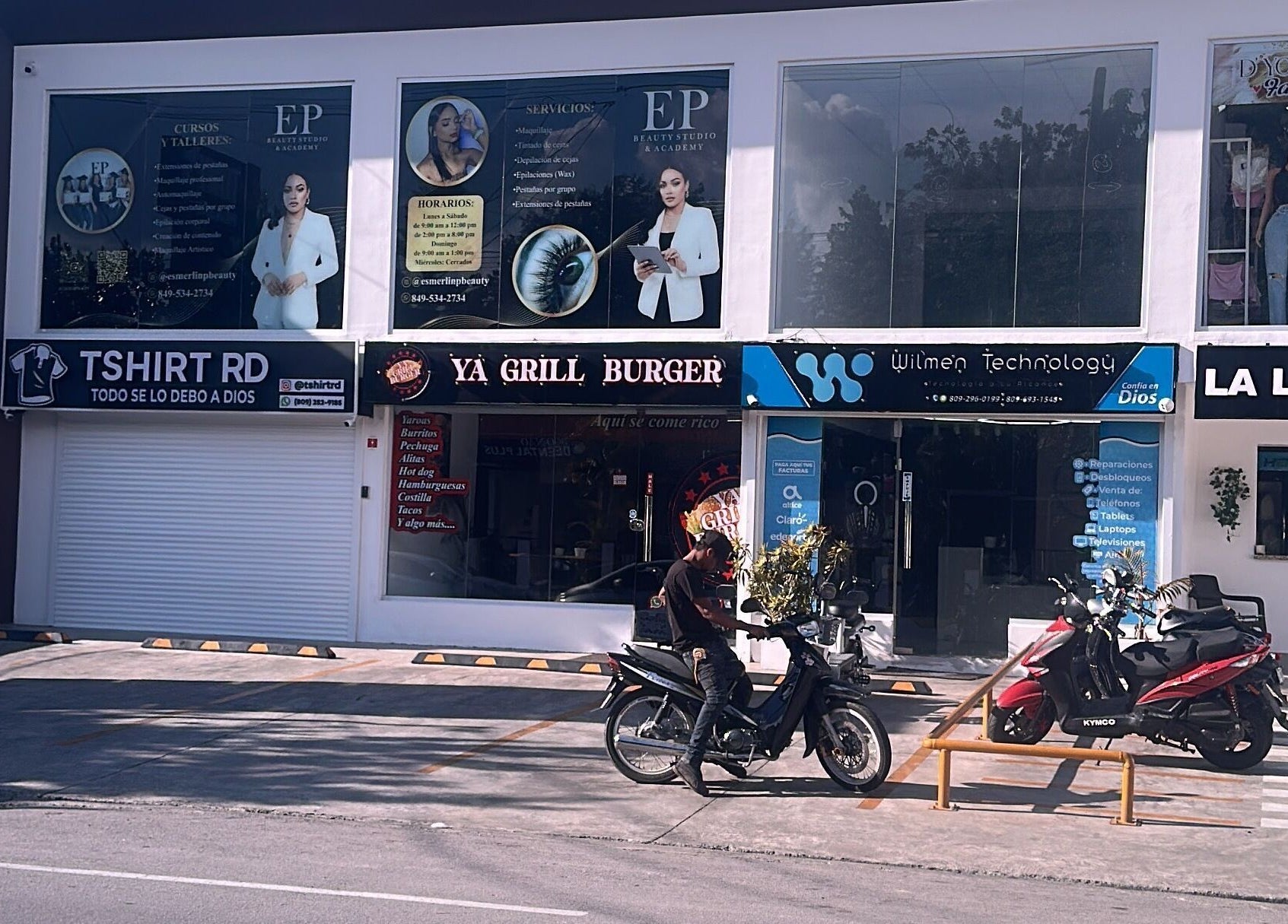 Exterior of EP Beauty Studio in Bonao, Monseñor Nouel, DO, showcasing vibrant signage and adjacent businesses.