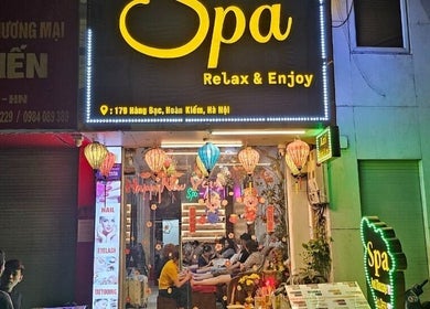 Mặt tiền Spa Relax & Enjoy, Hà Nội rực rỡ với đèn lồng màu sắc và khách hàng thư giãn bên trong.