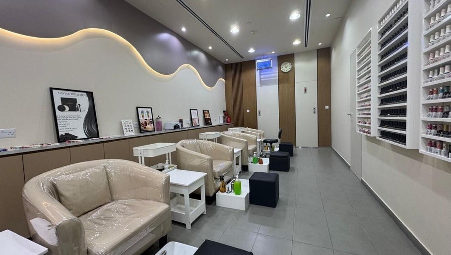 Elegant nail lounge at Layali Al Zahra Beauty Salon, Dubai, AE showcasing stylish seating and nail polish display.