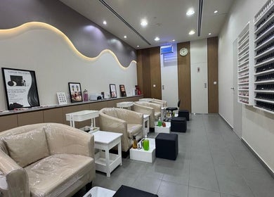 Elegant nail lounge at Layali Al Zahra Beauty Salon, Dubai, AE showcasing stylish seating and nail polish display.