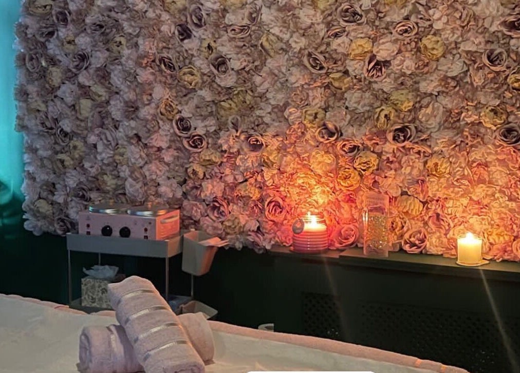Serene wellness room at Pinks Beauty & Spa in Hitchin, England, GB with floral wall and candlelight ambiance.