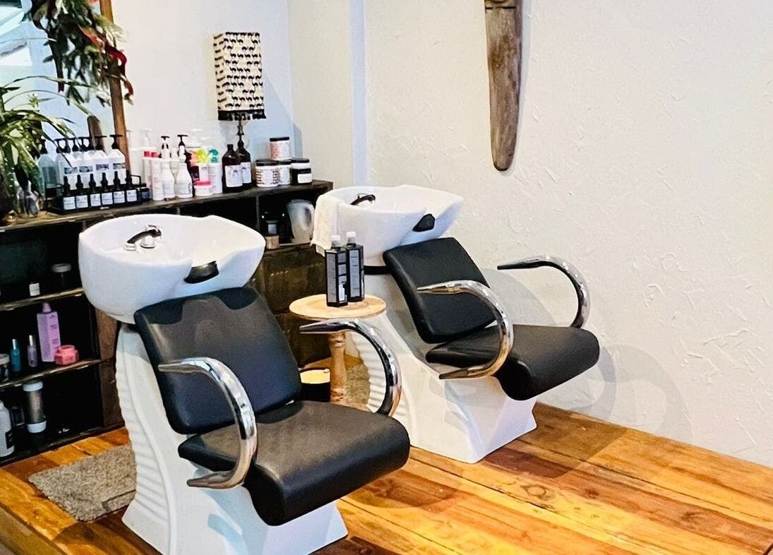 Área de lavado en Rivalbo, Grecia, Provincia De Alajuela, CR. Sillas cómodas y productos de belleza en exhibición.