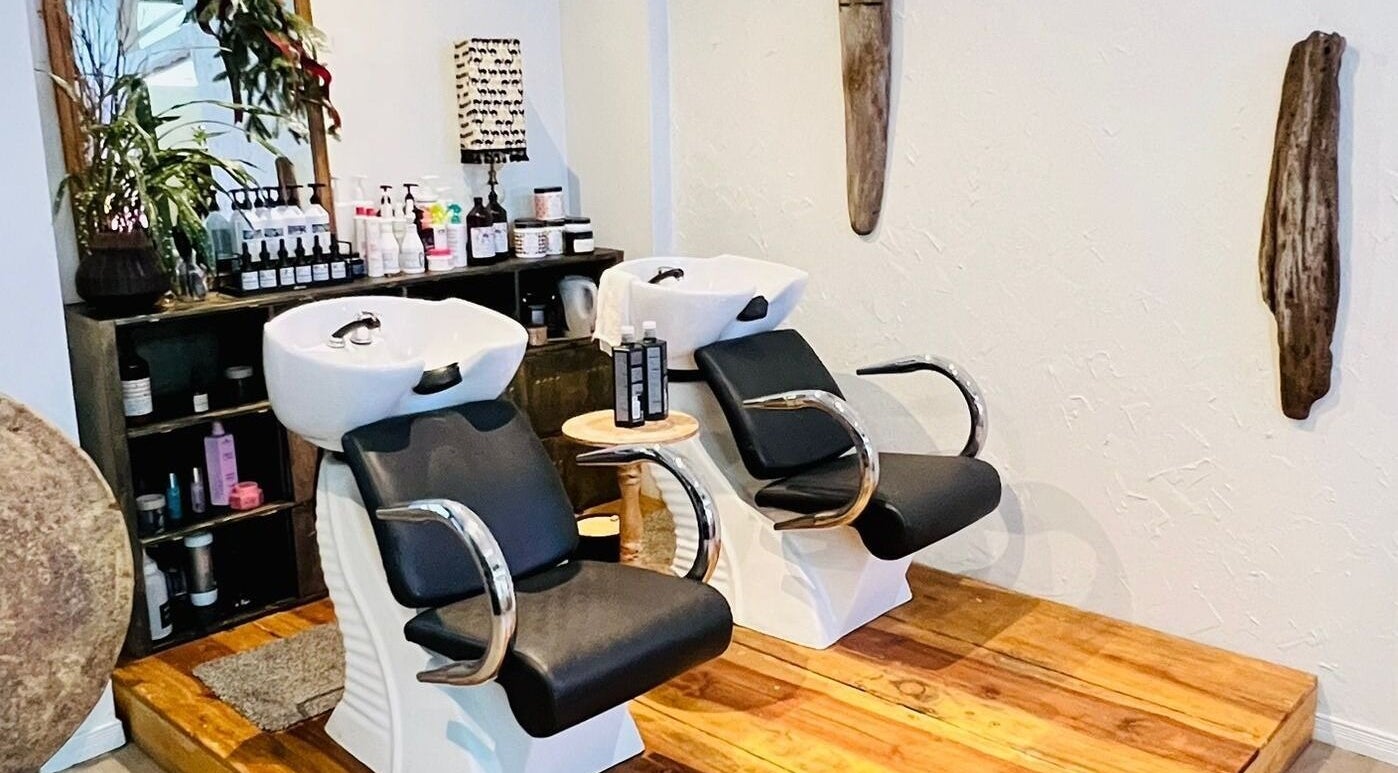 Área de lavado en Rivalbo, Grecia, Provincia De Alajuela, CR. Sillas cómodas y productos de belleza en exhibición.